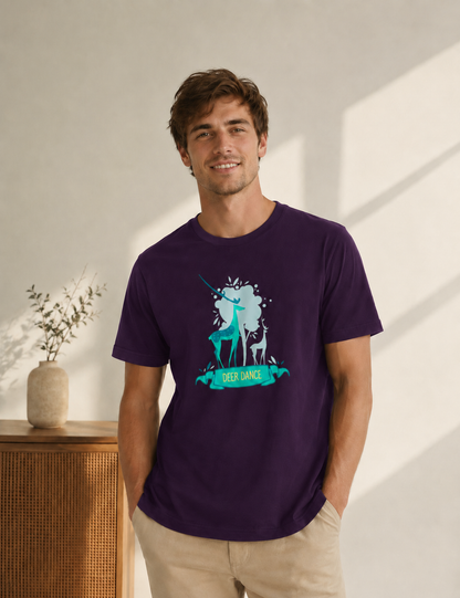 Man wearing a purple t-shirt with a graphic design of a deer and unicorn, standing in a bright room.