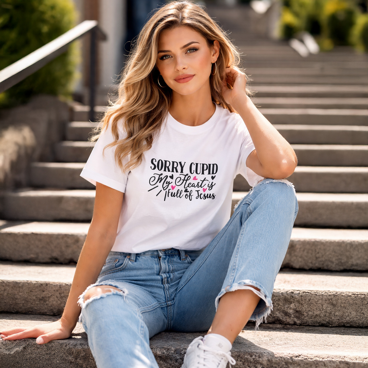 Woman wearing a white t-shirt with a humorous message sitting on steps.