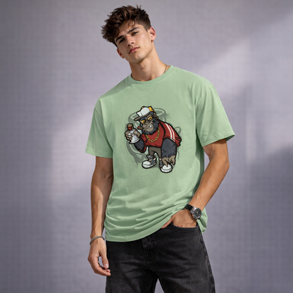 Person wearing a light green t-shirt with a graphic design of a gorilla wearing a hat and jacket on a gray background.
