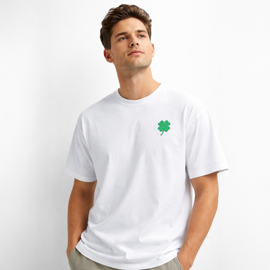 Man wearing a white t-shirt with a green four-leaf clover design on a light gray background