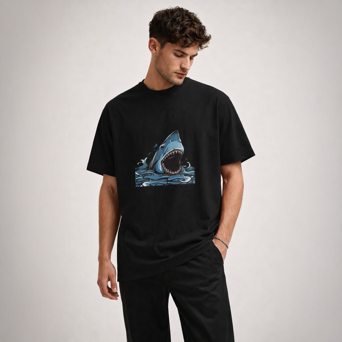 Man wearing a black t-shirt with a shark graphic on a plain background