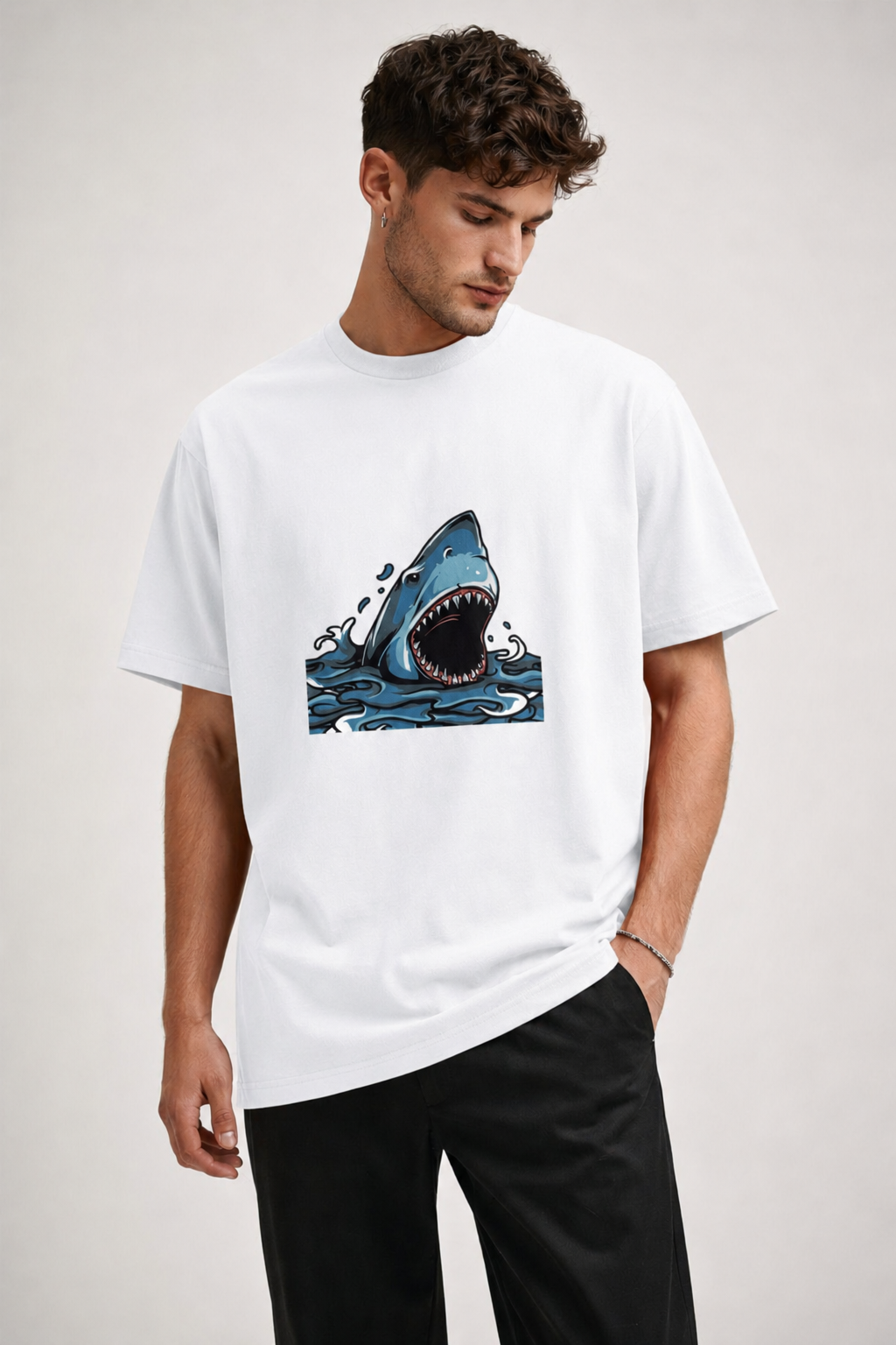 Man wearing a white t-shirt with a shark graphic on a plain background