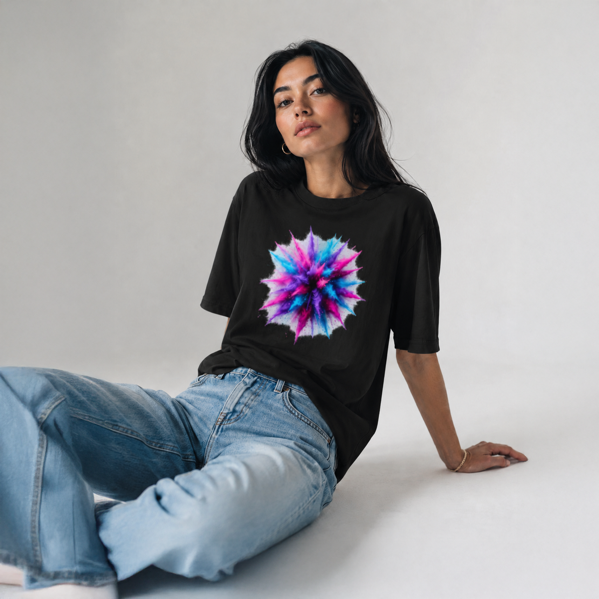 Person wearing a black t-shirt with a colorful starburst design on a plain background