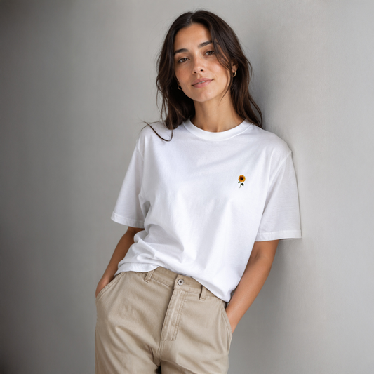 Woman wearing a white t-shirt with a small graphic on a plain background
